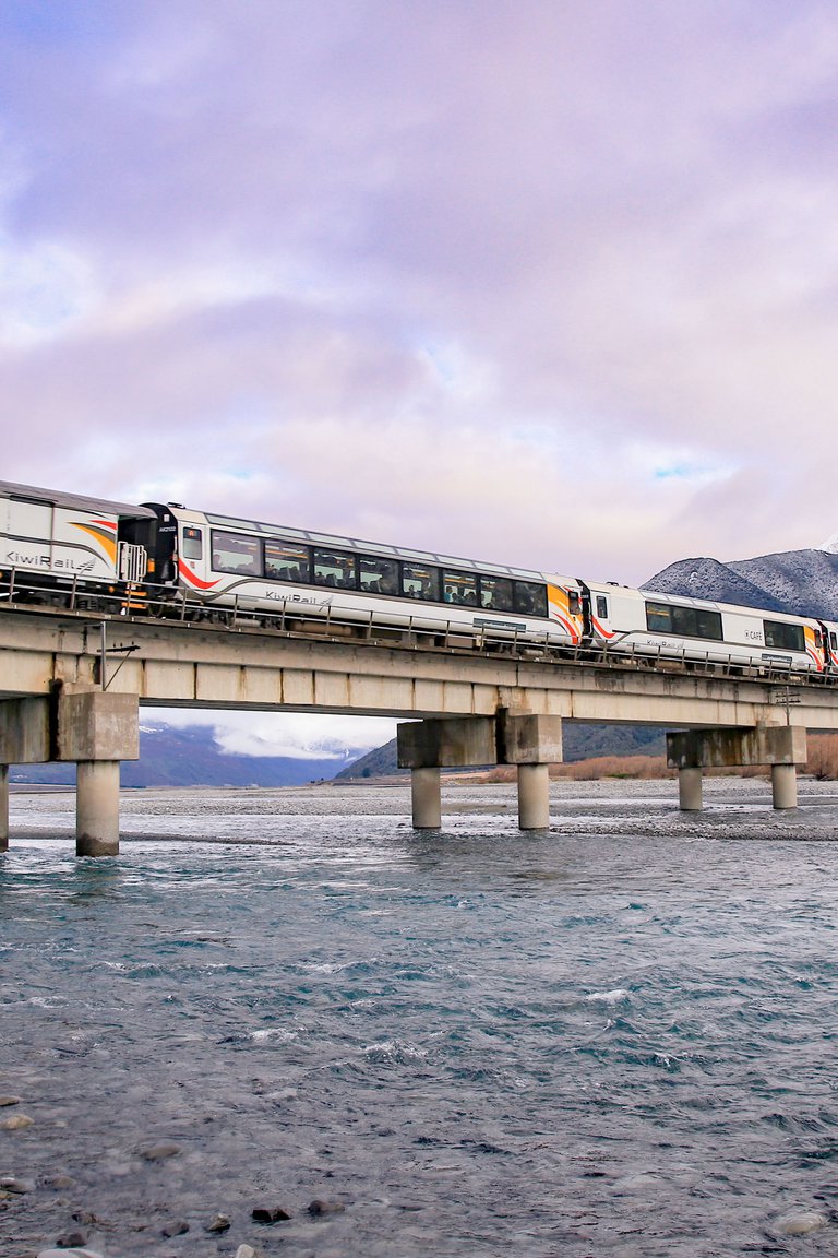 TranzAlpine train crossing a wintry Waimakariri River high in the Southern Alps near Cass.